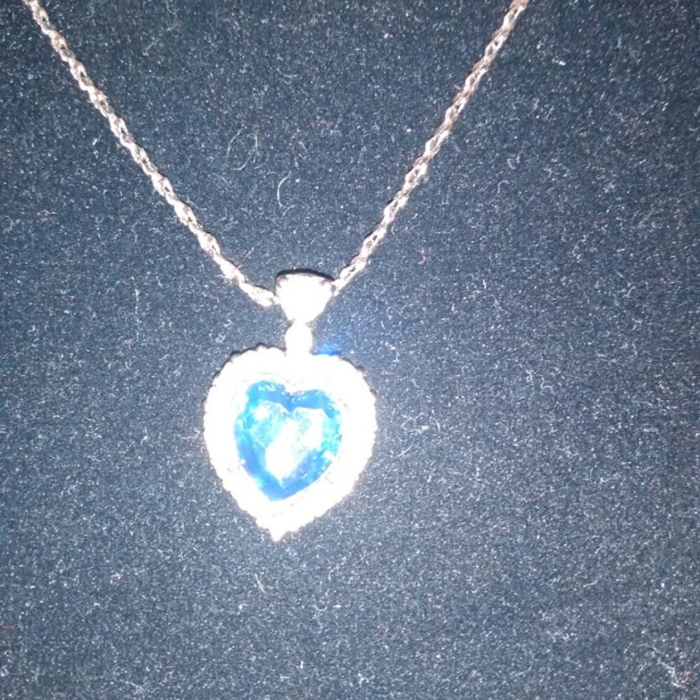 Silver tone heart shaped pendent necklace with Rhinestones & center blue stone.